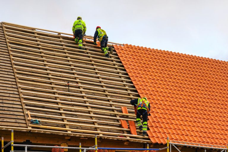 workers installing new roofing materials